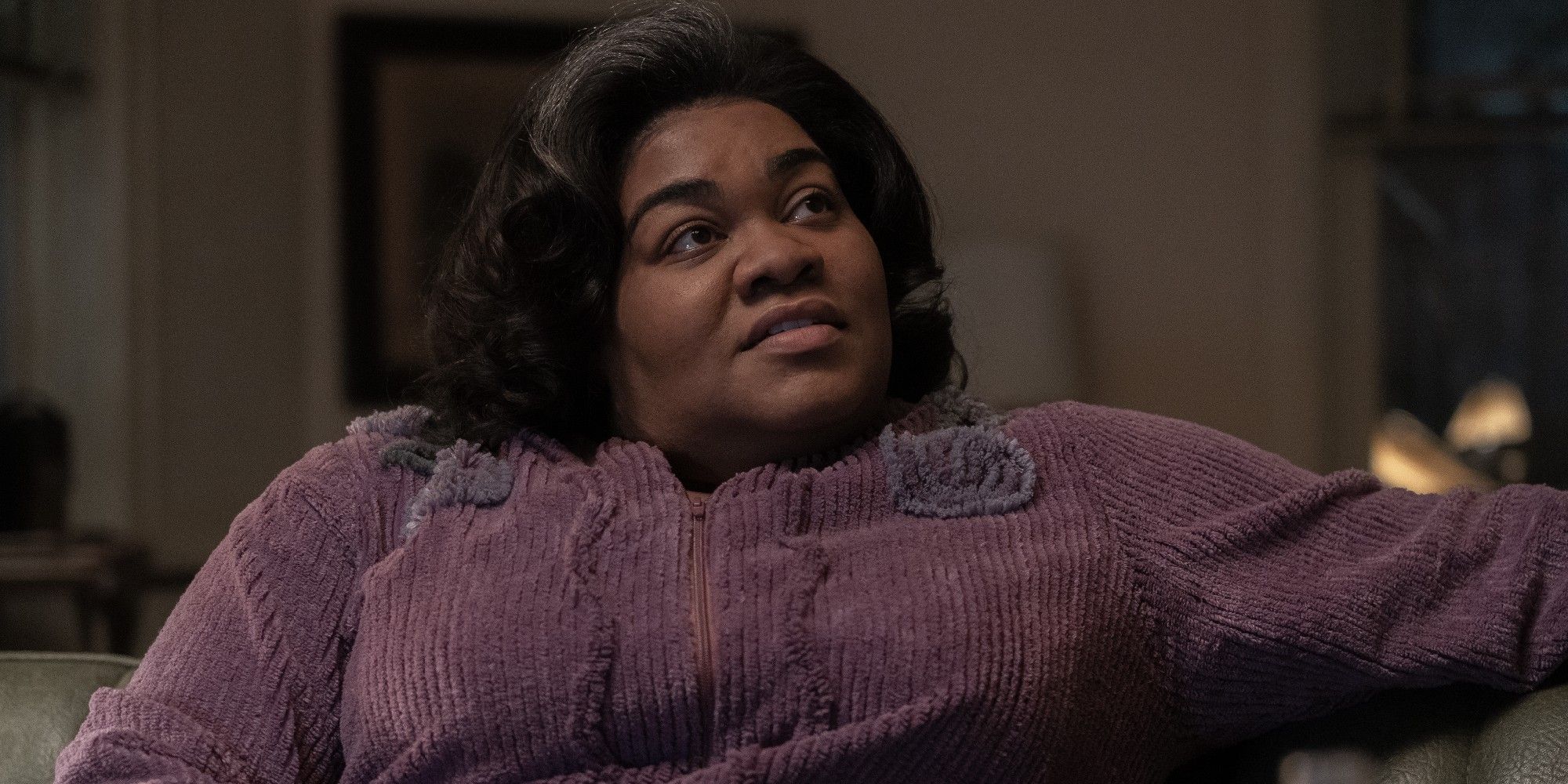 Mary (DaVine Joy Randolph) mengenakan pakaian ungu, duduk di The Holdovers